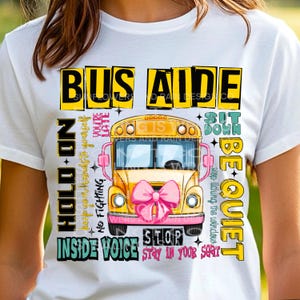 May include: A white t-shirt with a yellow school bus graphic and text that reads "Bus Aide", "Hold On", "No Fighting", "You're Late", "Sit Down", "Be Quiet", "Inside Voice", "Stop", and "Stay in Your Seat".