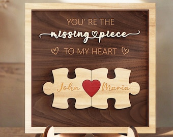 May include: Wooden sign with a jigsaw puzzle design and the text "You're the missing piece to my heart." The puzzle pieces are labeled "John" and "Maria" with a red heart in the middle.