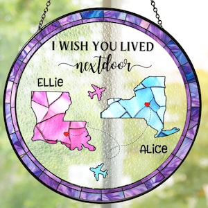 May include: Circular stained glass window art with a hanging chain. The design includes the text "I wish you lived nextdoor" and two state outlines, Louisiana and New York, with names and hearts.