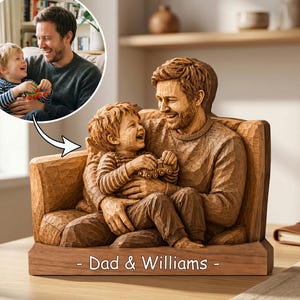 May include: A wooden sculpture of a father and child seated together, carved from a light brown wood. The child is seated on the father's lap, both smiling. The base of the sculpture reads "- Dad & Williams -."