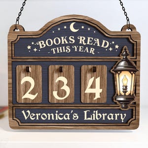 May include: Wooden sign with the text "BOOKS READ THIS YEAR" and "Veronica's Library". The sign has a dark blue background with the numbers "234" and a decorative lantern.
