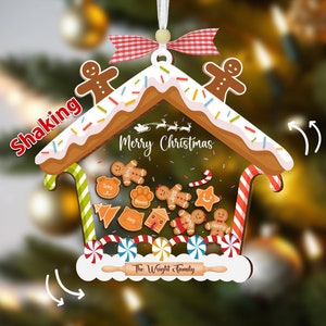 May include: Gingerbread house Christmas ornament with the text "Merry Christmas" and "The Wright Family". The ornament features gingerbread men, candy canes, and a rolling pin. It is decorated with white icing and colorful sprinkles.