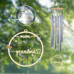 May include: A wooden wind chime with a crystal prism and a circular design featuring the text "FIRST mom Growing Since 1983 NOW grandma Growing Since 2024" with butterflies and flowers around the circle.