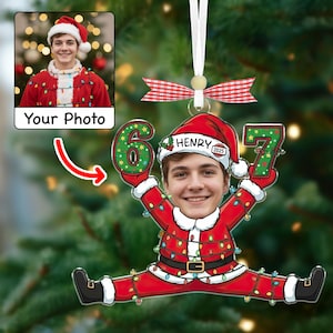 May include: A personalized Christmas ornament featuring a photo of a person in a Santa hat and suit. The ornament is shaped like a person doing a split, holding the numbers "6" and "7". The name "Henry" is on the Santa hat.