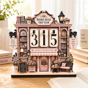 May include: A pink wooden bookstore-themed perpetual calendar featuring the text BOOKS READ THIS YEAR, SOPHIA'S BOOKSTORE, and signs reading Every book is a new adventure, Read more worry less, and Collect moments, not things. Collect books.