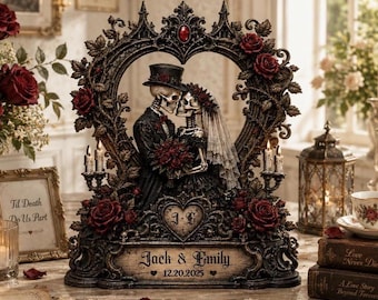 May include: A decorative sculpture featuring two skeletons dressed as a bride and groom, framed by an ornate heart-shaped arch with red roses and candles. The base displays the text Jack & Emily and the date 12.20.2025 with a heart emblem.