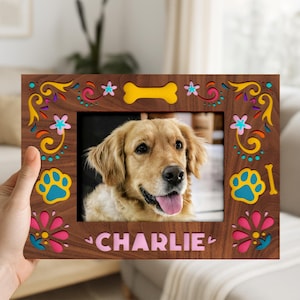 May include: A wooden photo frame with a picture of a golden retriever dog. The frame is brown with colorful floral and paw print designs. The dog's name, "CHARLIE", is printed at the bottom of the frame.