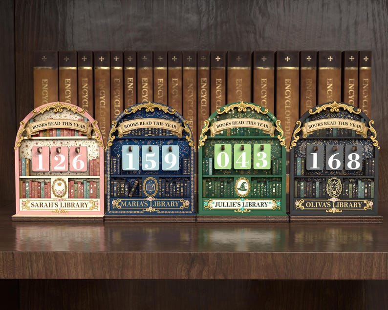 May include: Four decorative wooden book counters in pink, blue, green, and black, each with a different number displayed. The counters have a library theme, with the words "Books Read This Year" above the numbers and the names "Sarah's Library", "Maria's Library", "Jullie's Library", and "Oliva's Library" below.