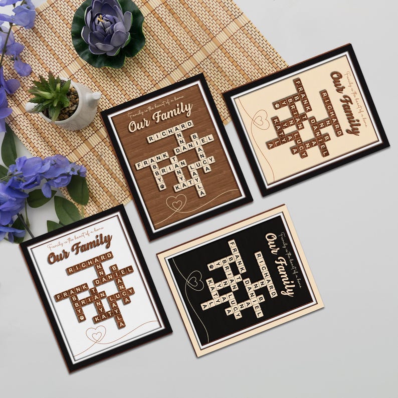 May include: Four framed prints with the words "Our Family" and a scrabble tile crossword puzzle featuring family names. The prints have different colored backgrounds: brown wood, cream, black, and white.