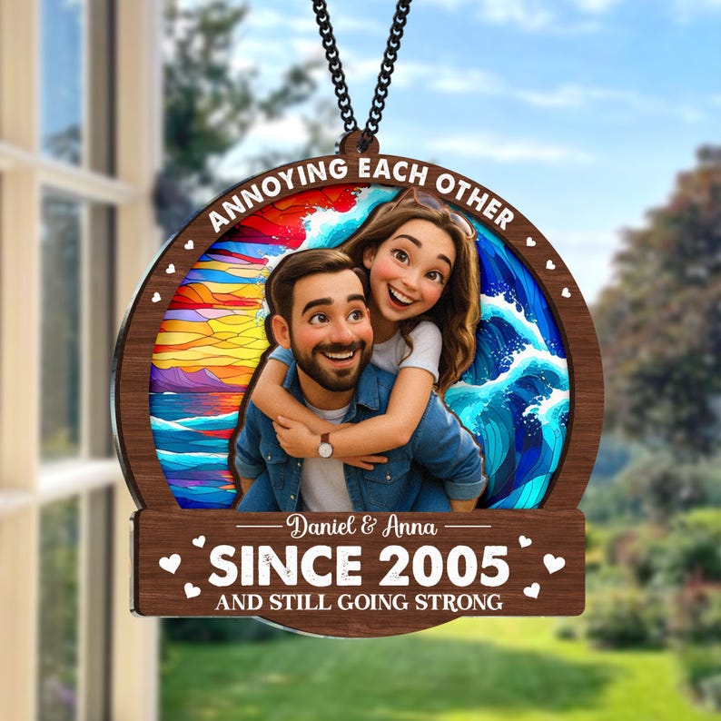 May include: A wooden ornament with a photo of a couple hugging, with the text "ANNOYING EACH OTHER" at the top. The bottom of the ornament reads "SINCE 2005 AND STILL GOING STRONG" with the names "Daniel & Anna" below the photo.