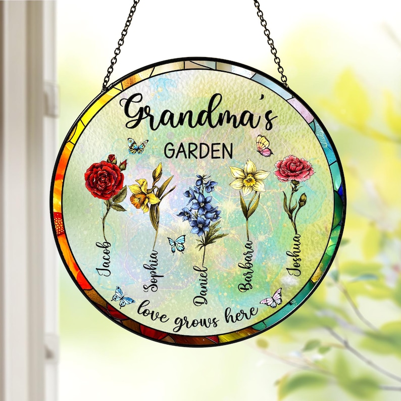 May include: A round stained glass window hanging with a colorful floral design and the text "Grandma's Garden" with the names Jacob, Sophia, Daniel, Barbara, and Joshua. The text "Love grows here" is at the bottom of the window.