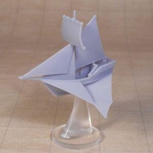 Può includere: Un modello di barca a vela in miniatura lilla chiaro con vele e albero. La barca è montata su un supporto trasparente con una base circolare. Il modello è probabilmente stampato in 3D ed è un oggetto decorativo.