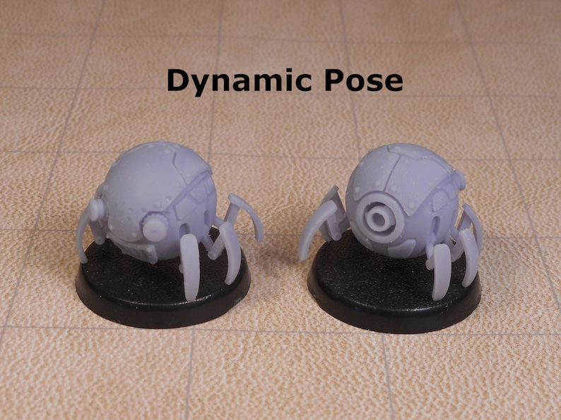 May include: Two gray, robotic spider-like figures with multiple legs and a round body. The figures are posed in a dynamic way, with one figure facing forward and the other facing backward. The figures are on black bases.