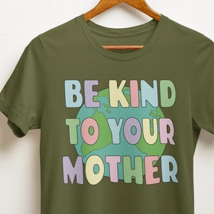 May include: A green t-shirt with the text "BE KIND TO YOUR MOTHER" in rainbow colors with a cartoon earth graphic.
