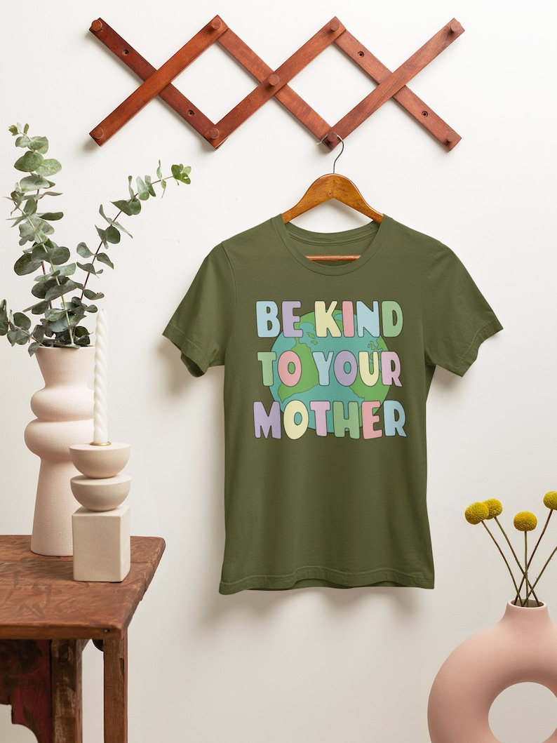 May include: A green t-shirt with the text "BE KIND TO YOUR MOTHER" in rainbow colors with a cartoon earth graphic.