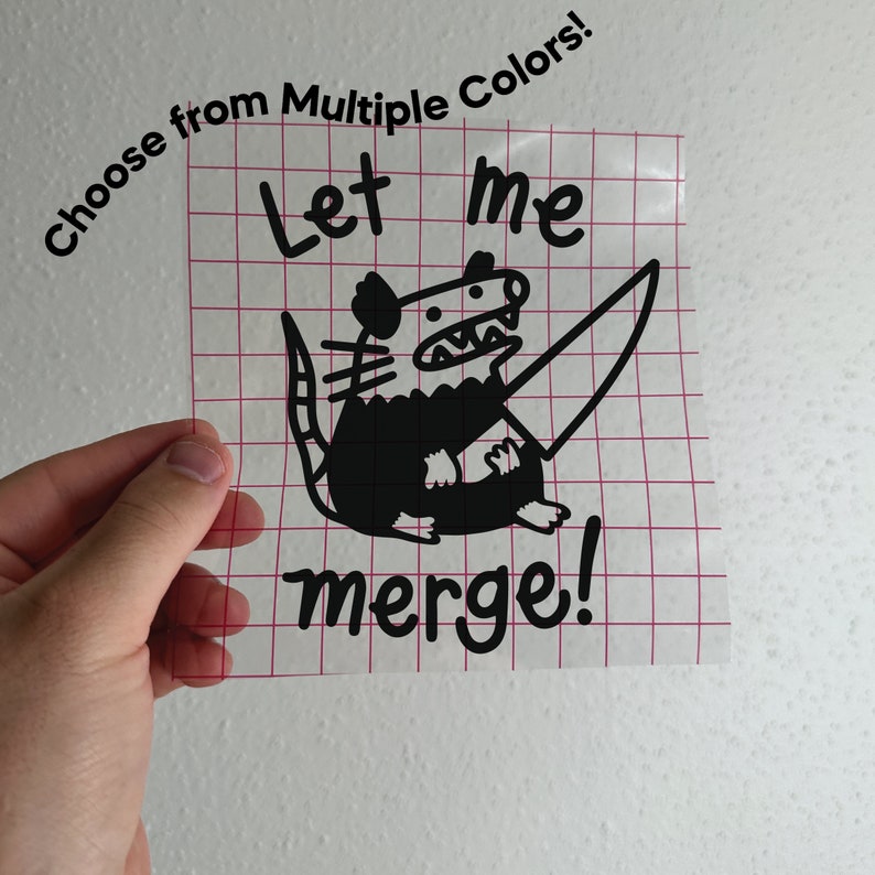Op de afbeelding: Een zwart-witte sticker met een cartoon-opossum dat een mes vasthoudt en de tekst "Let me merge!" De sticker zit op een transparant vel met een rood rasterpatroon. Kies uit meerdere kleuren.