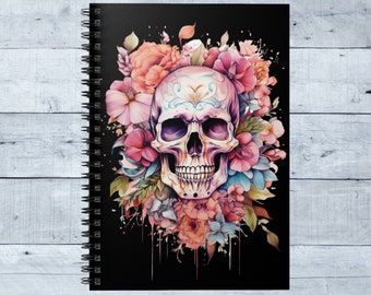 May include: A black spiral notebook with a colorful sugar skull surrounded by pink, blue, and purple flowers. The skull has intricate details and is painted in a traditional style.