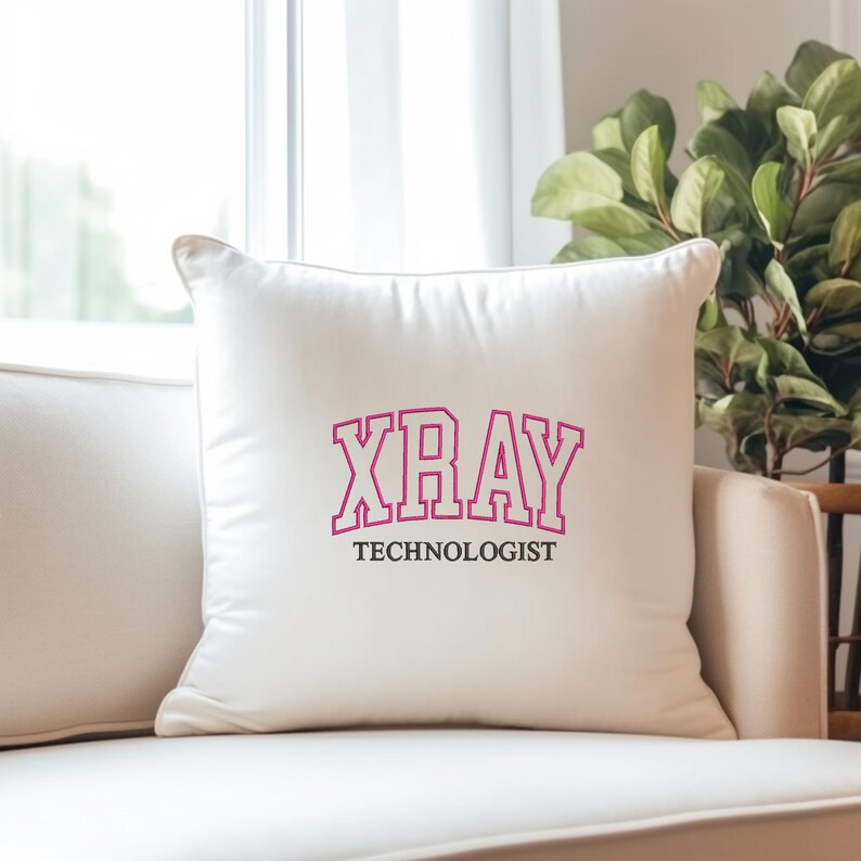 K&ouml;nnte beinhalten: Ein wei&szlig;es Kissen mit dem Text "XRAY TECHNOLOGIST" in rosa und schwarzen Buchstaben.
