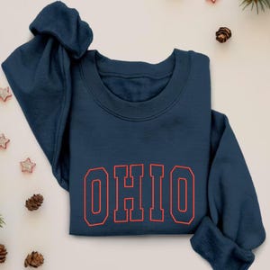 May include: A navy blue sweatshirt with the word "OHIO" in red outlined letters.