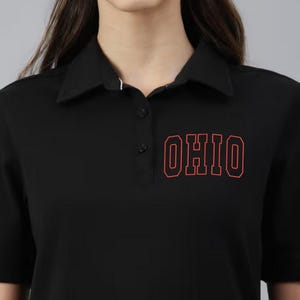 May include: Black polo shirt with a red outline of the word "OHIO" on the front.