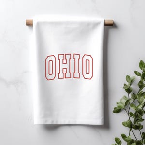 May include: White kitchen towel with the word "OHIO" printed in red with a white outline.