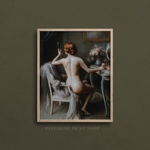 May include: A painting of a woman sitting in a chair in front of a vanity. She is holding a hand mirror and looking at her reflection. The woman has red hair and is nude. The vanity is decorated with flowers and a small mirror. The painting is done in a realistic style and has a warm color palette.
