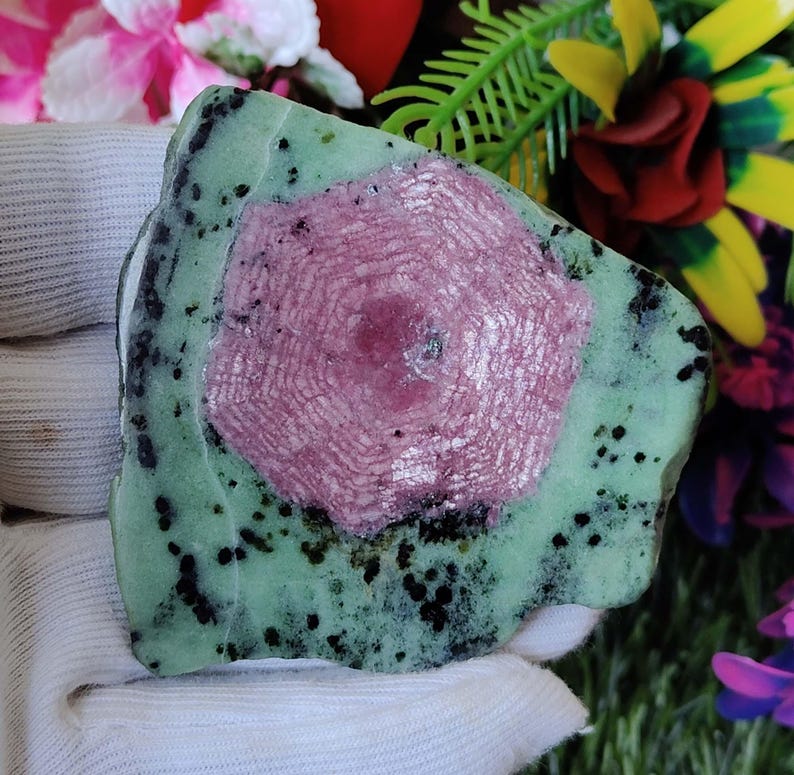 Puede incluir: Una piedra preciosa verde y rosa con un patr&oacute;n de estrella. La piedra preciosa es rugosa y tiene un aspecto natural sin pulir.