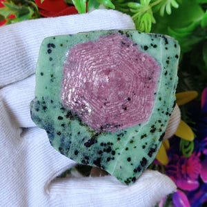 Pu&ograve; includere: Una pietra preziosa verde e rosa con un motivo a forma di stella. La pietra preziosa &egrave; grezza e ha un aspetto naturale non levigato.