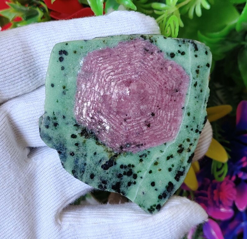 Pu&ograve; includere: Una pietra preziosa verde e rosa con un motivo a forma di stella. La pietra preziosa &egrave; grezza e ha un aspetto naturale non levigato.