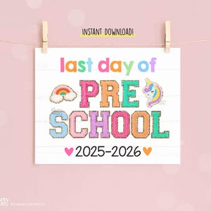 Puede incluir: Un letrero blanco con las palabras "last day of PRE SCHOOL 2025-2026" en letras coloridas y brillantes. El letrero incluye gráficos de arcoíris y unicornios, y está suspendido por una pinza de madera sobre un fondo rosa.
