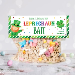 Könnte beinhalten: Ein klarer Plastikbeutel gefüllt mit Müsli und bunten Marshmallows, gekrönt von einem Etikett zum Thema St. Patrick's Day. Das Etikett lautet "Happy St. Patrick's Day! Leprechaun Bait" mit einer Leprechaun-Illustration und einem vierblättrigen Kleeblatt.