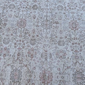 May include: A vintage rug with a floral pattern in shades of beige, brown, and pink.