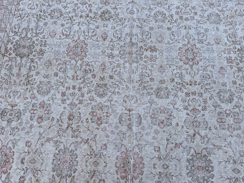 May include: A vintage rug with a floral pattern in shades of beige, brown, and pink.