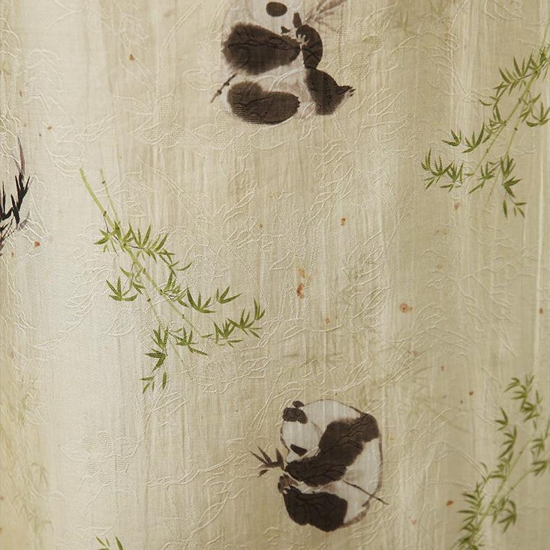 Pu&ograve; includere: Un tessuto beige chiaro caratterizzato da un sottile motivo floreale in rilievo su tutta la superficie. Il materiale &egrave; decorato con illustrazioni stampate di panda bianchi e neri in varie pose, intervallate da delicati rami e foglie di bamb&ugrave;.