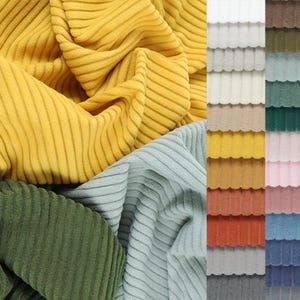 May include: A collection of fabric swatches in various colors and textures. The swatches are all ribbed and have a corduroy-like texture. The colors include yellow, green, blue, white, beige, brown, orange, pink, and gray.