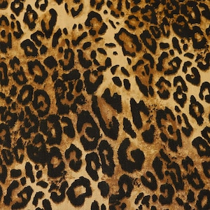 Può includere: Primo piano di un tessuto con stampa leopardata. Il design presenta macchie marrone scuro e nere su uno sfondo beige. Le macchie variano per dimensioni e forma, creando un'estetica naturale e animale. Il tessuto sembra essere un materiale tessuto.