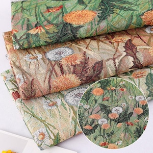 Op de afbeelding: Close-up van een tapijtstof met een bloemenpatroon met paardenbloemen in tinten groen, bruin en wit. De stof is geweven met een textuur, verhoogd ontwerp.