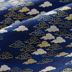 May include: Blue fabric with a repeating pattern of white and gold clouds. The clouds are stylized and have a swirling design.