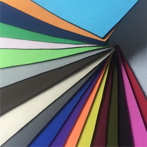 May include: A variety of colors of neoprene fabric swatches. The swatches are arranged in a fan shape, with the lightest color at the top and the darkest color at the bottom.