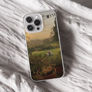 iPhone 15 14 13 12 11 clear case with Nature and Cottage core design on it, there are total of five options to choose from. Aesthetic flowers, river, plains, book lover artwork are depicted.