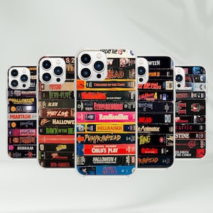 May include: Five phone cases with a clear border, each featuring a stack of VHS tapes with horror movie titles like "Halloween," "Nightmare on Elm Street," and "Child's Play." The cases are arranged in a row.