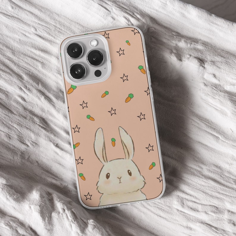 iPhone 15 14 13 12 11 clear case with Cute Bunny design on it, there are total of five phone cover options to choose from. Nature core rabbit, cottage core flower pattern, farm life, carrot, animal cover artwork are depicted.