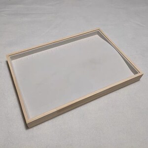 May include: A wooden jewelry tray with a white velvet lining and multiple slots for earrings.