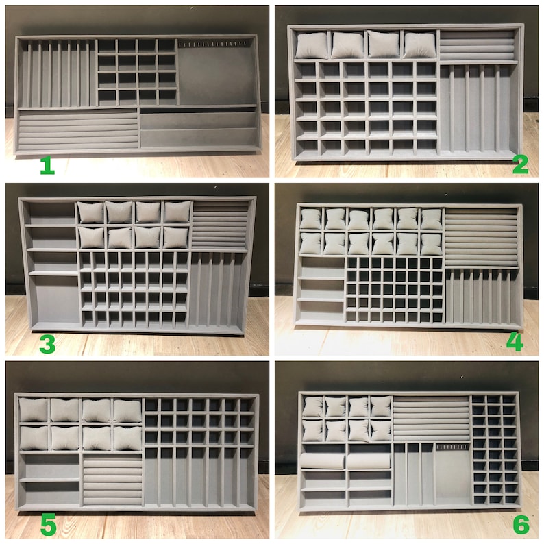 May include: Six different styles of gray jewelry organizers with compartments for rings, earrings, bracelets, and necklaces. Each organizer has a different configuration of compartments and slots.