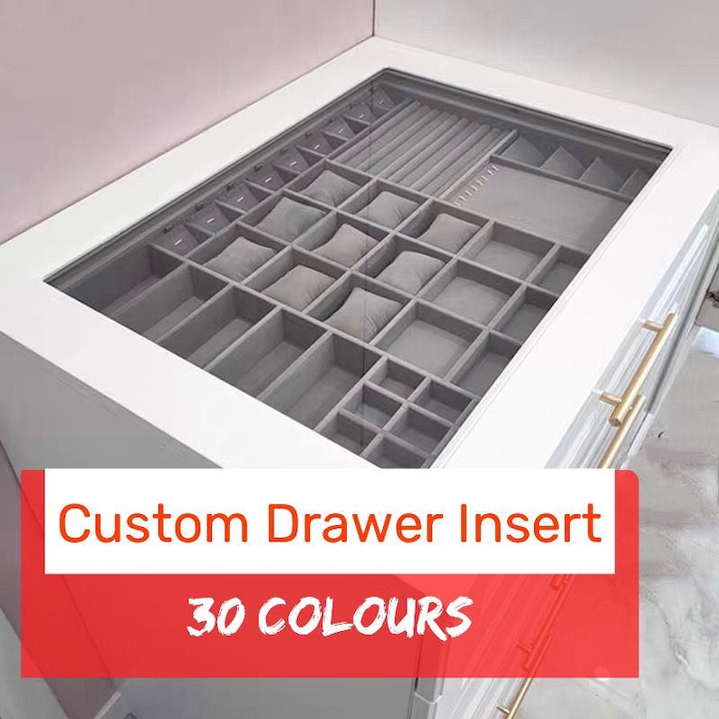 May include: A custom drawer insert with a gray felt lining and multiple compartments for jewelry and watches. The insert is made to fit a drawer and has a white frame. The text "Custom Drawer Insert" and "30 COLOURS" is printed on the front of the drawer.