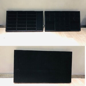 May include: Two black velvet-lined jewelry trays with compartments for storing rings, earrings, and other small items. The trays are separated by a black velvet-lined base.