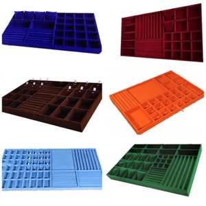 May include: Six different jewelry organizer trays with various compartments and dividers. The trays are made of a soft, velvety material and come in blue, red, brown, orange, light blue, and green.