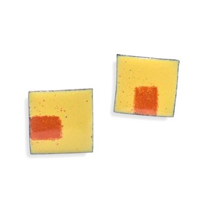 Peut inclure: Une paire de boucles d'oreilles carrées jaunes avec un petit motif carré orange au centre.