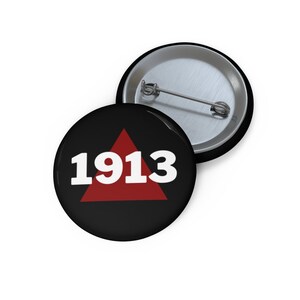 May include: A black button with a red triangle and the number 1913 in white text.