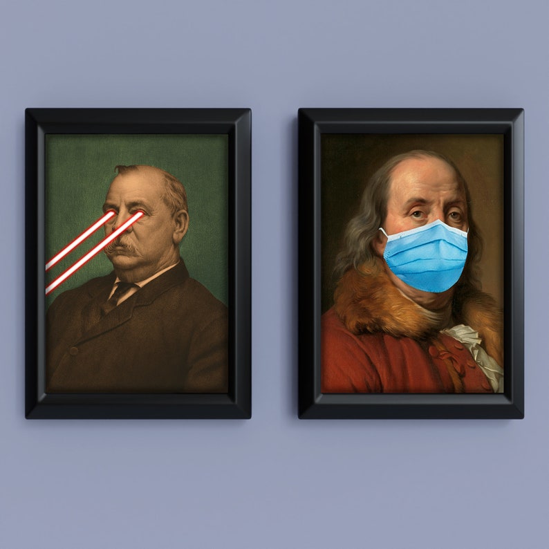May include: Two framed portraits. One features a man with red laser beams for eyes. The other shows a man wearing a blue surgical mask. Both portraits are in black frames and set against a light blue background.